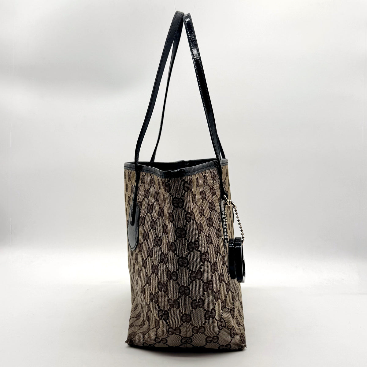 Gucci Tote Toile GG Beige et Cuir Verni Noir - profil opposé, breloque visible