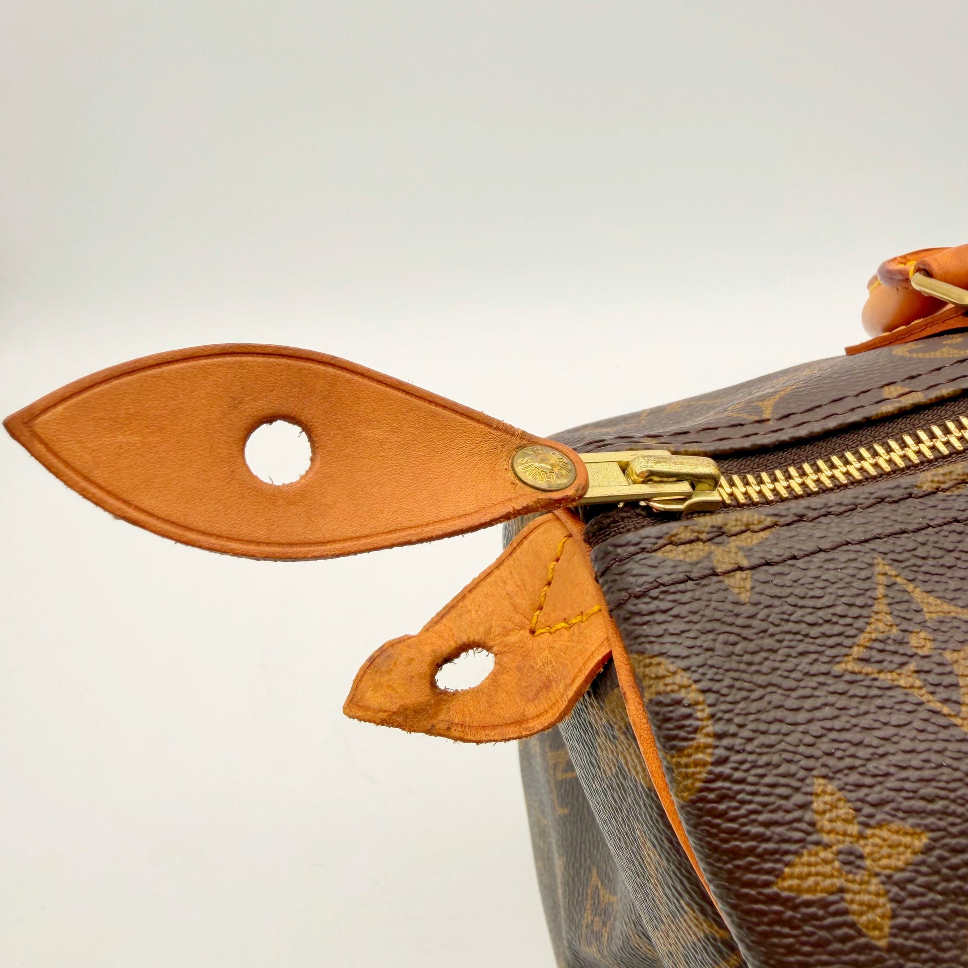 Louis Vuitton Speedy 30 toile Monogram - détail de la tirette et de la patte latérale
