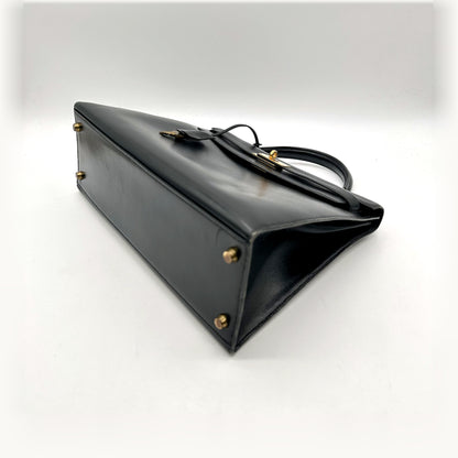 Hermès Kelly 32 Cuir Box Calf Noir - vue du dessous en angle, clous de base