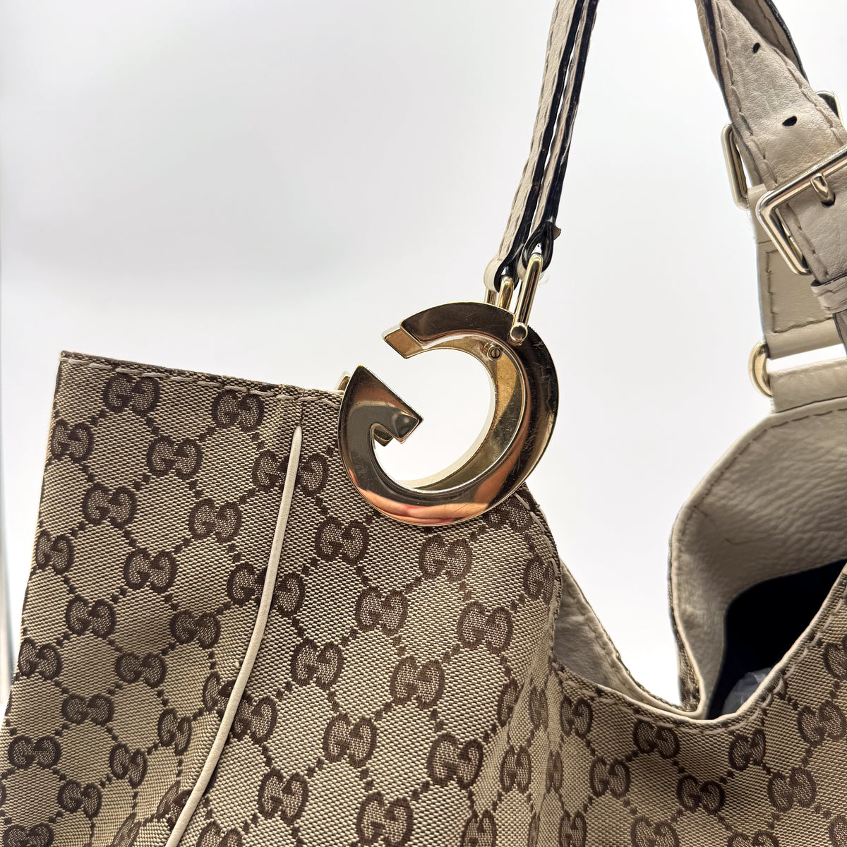 Gucci Tote Toile GG Beige et Cuir Crème - détail de l'anneau doré et de l'empiècement de cuir
