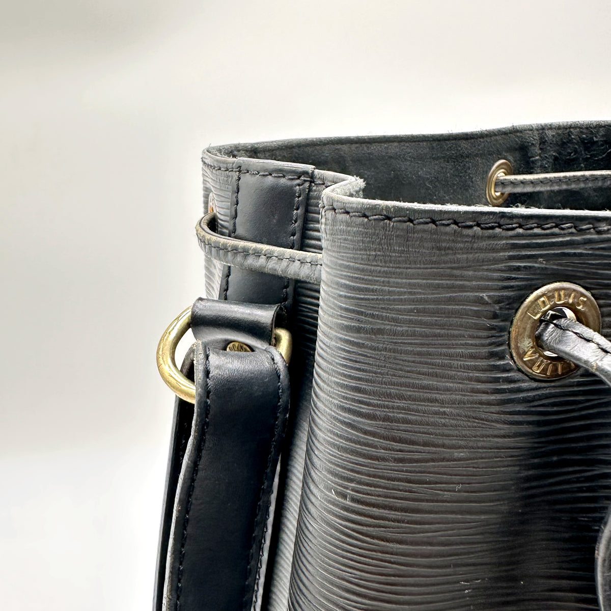 Louis Vuitton Noé Cuir Épi Noir - détail du haut du sac, œillets et attache de bandoulière