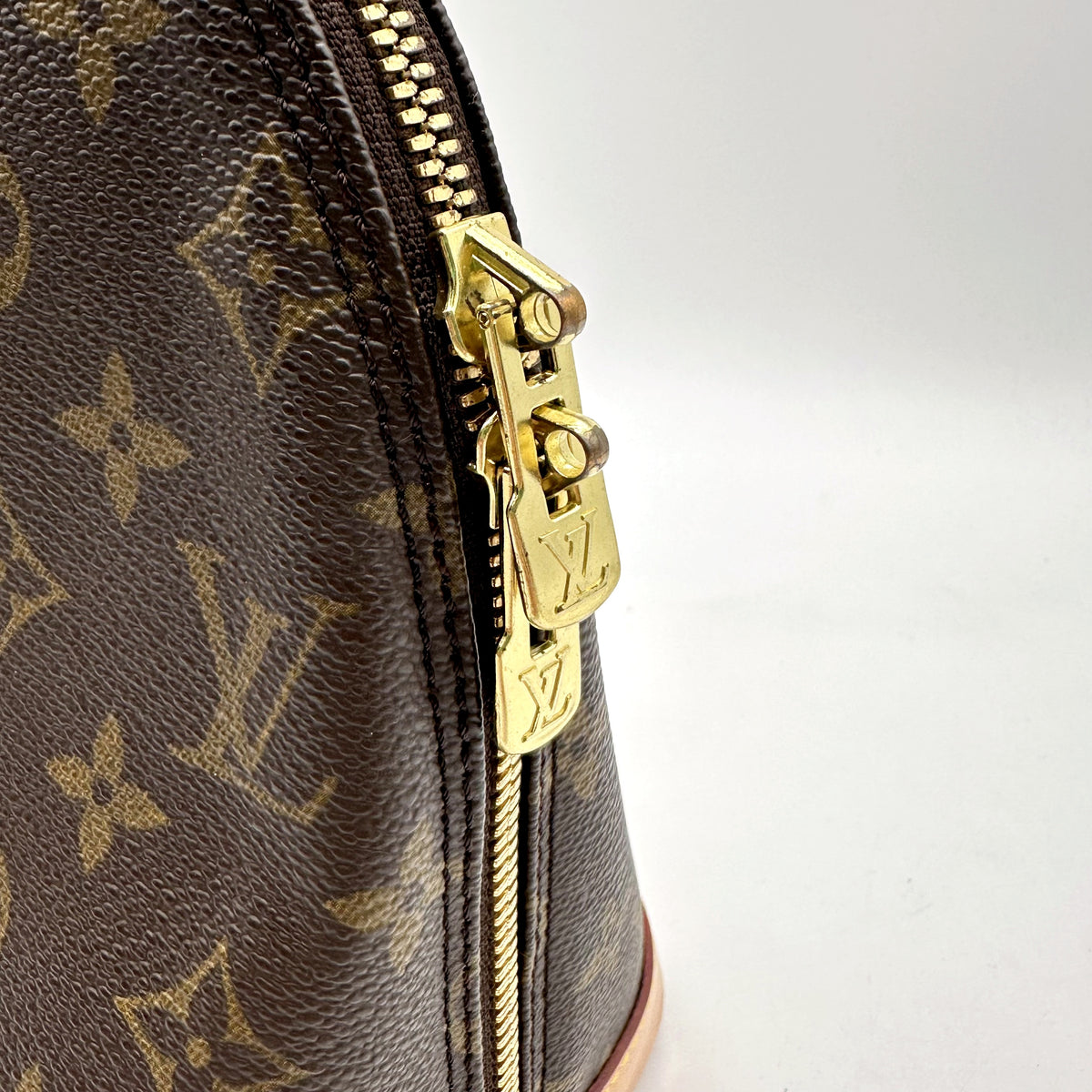 Louis Vuitton Alma Toile Monogram - détail du zip et de sa tirette dorée