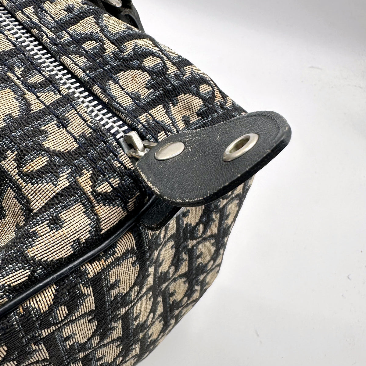 Dior Boston Toile Trotter Bleu Marine - détail du zip et de la patte de cuir à pression