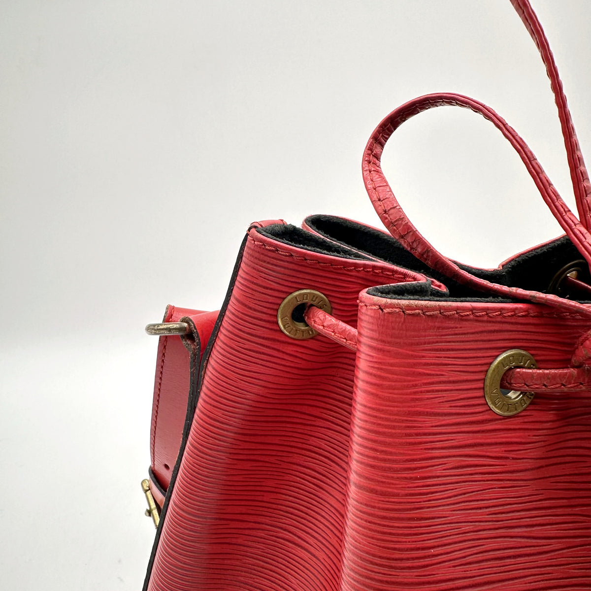 Louis Vuitton Petit Noé Cuir Épi Rouge - détail du haut du sac, œillets et cordon