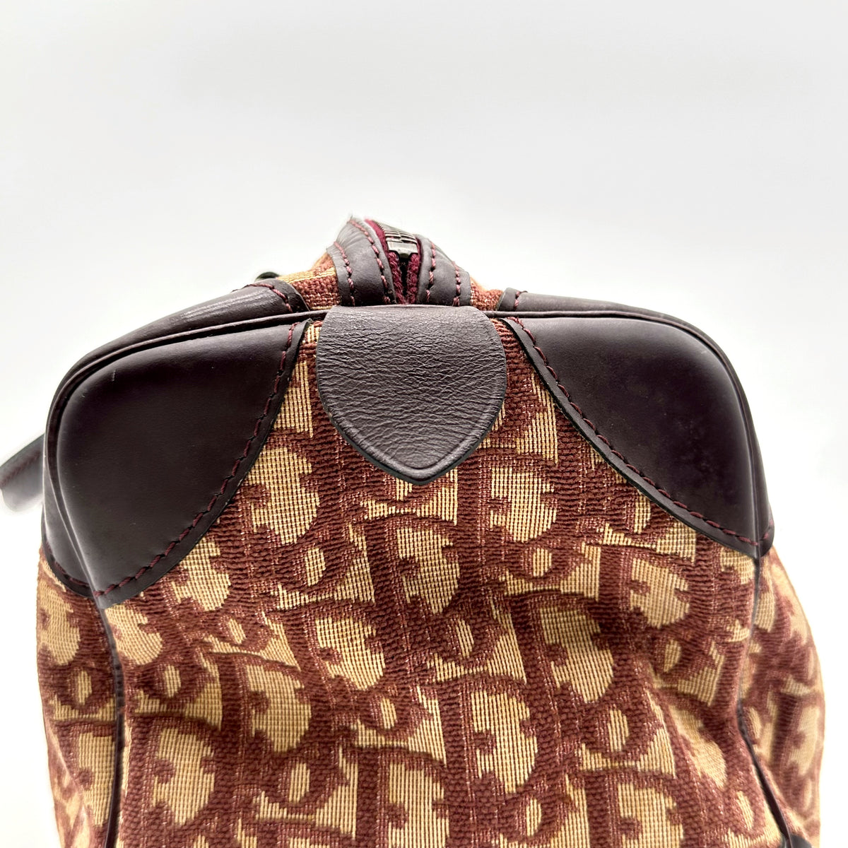 Dior Boston Toile Trotter Rouge - détail du haut du sac et des coins de cuir