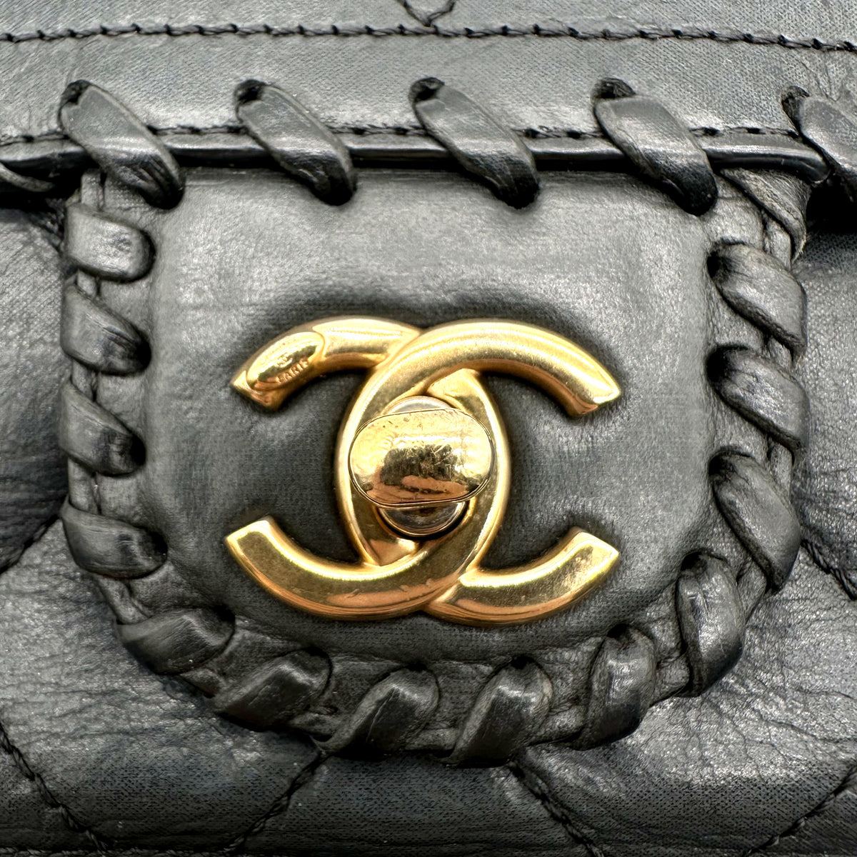 Chanel Matelassé Cuir Gris Anthracite - détail du fermoir CC et du contour tressé