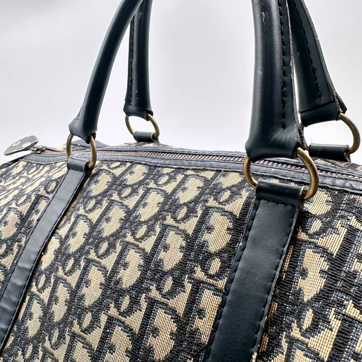 Dior Boston Toile Trotter Bleu Marine - détail des attaches d'anses et des anneaux dorés