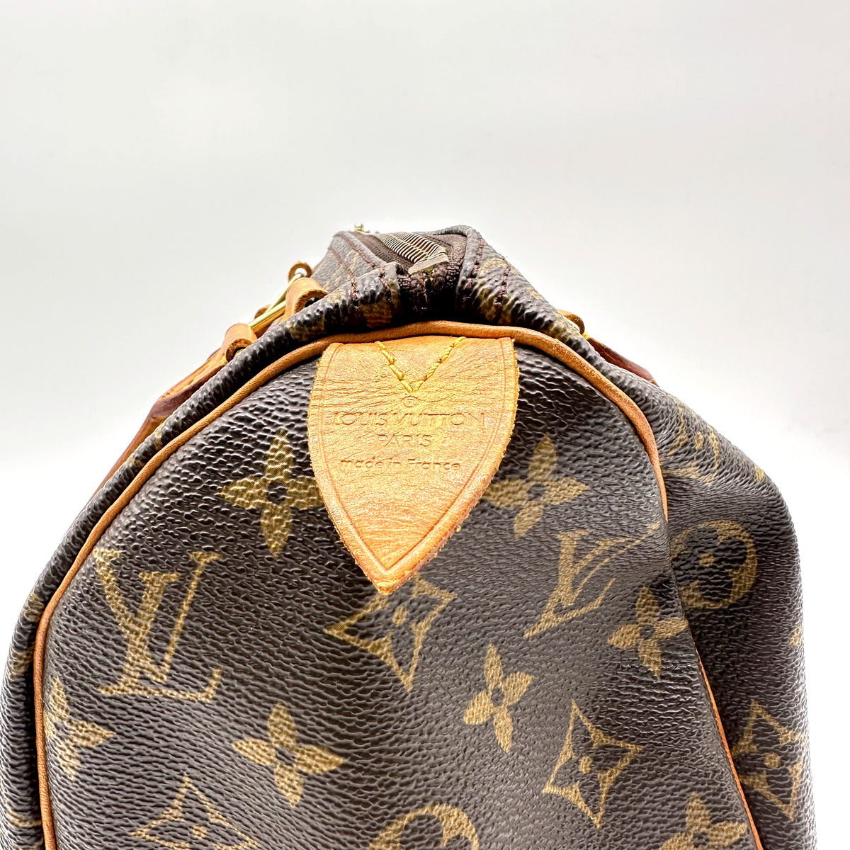 Louis Vuitton Speedy 25 Toile Monogram - détail de la patte de cuir estampée sous l'anse