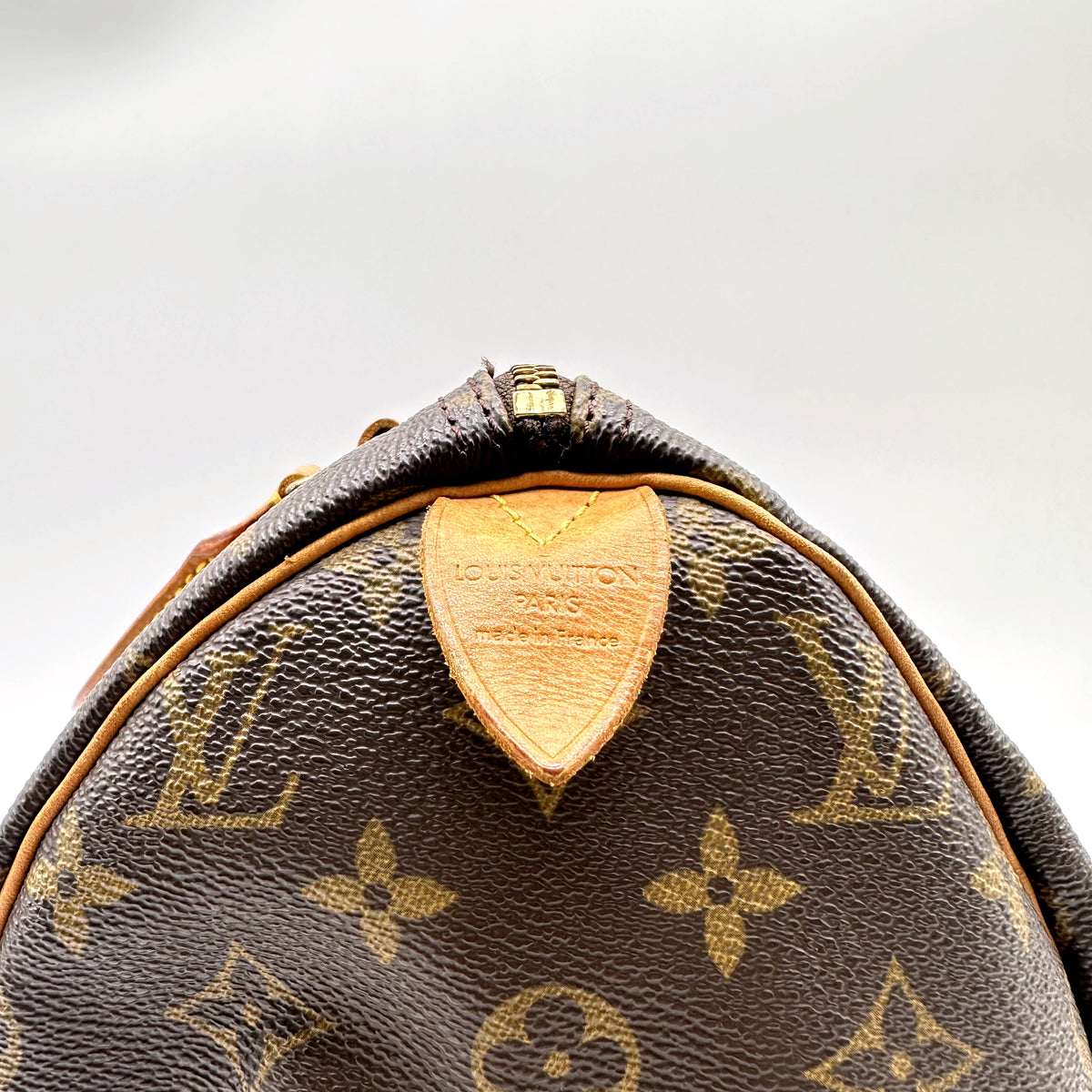 Louis Vuitton Speedy 30 Toile Monogram - détail de la patte de cuir estampée sous l'anse
