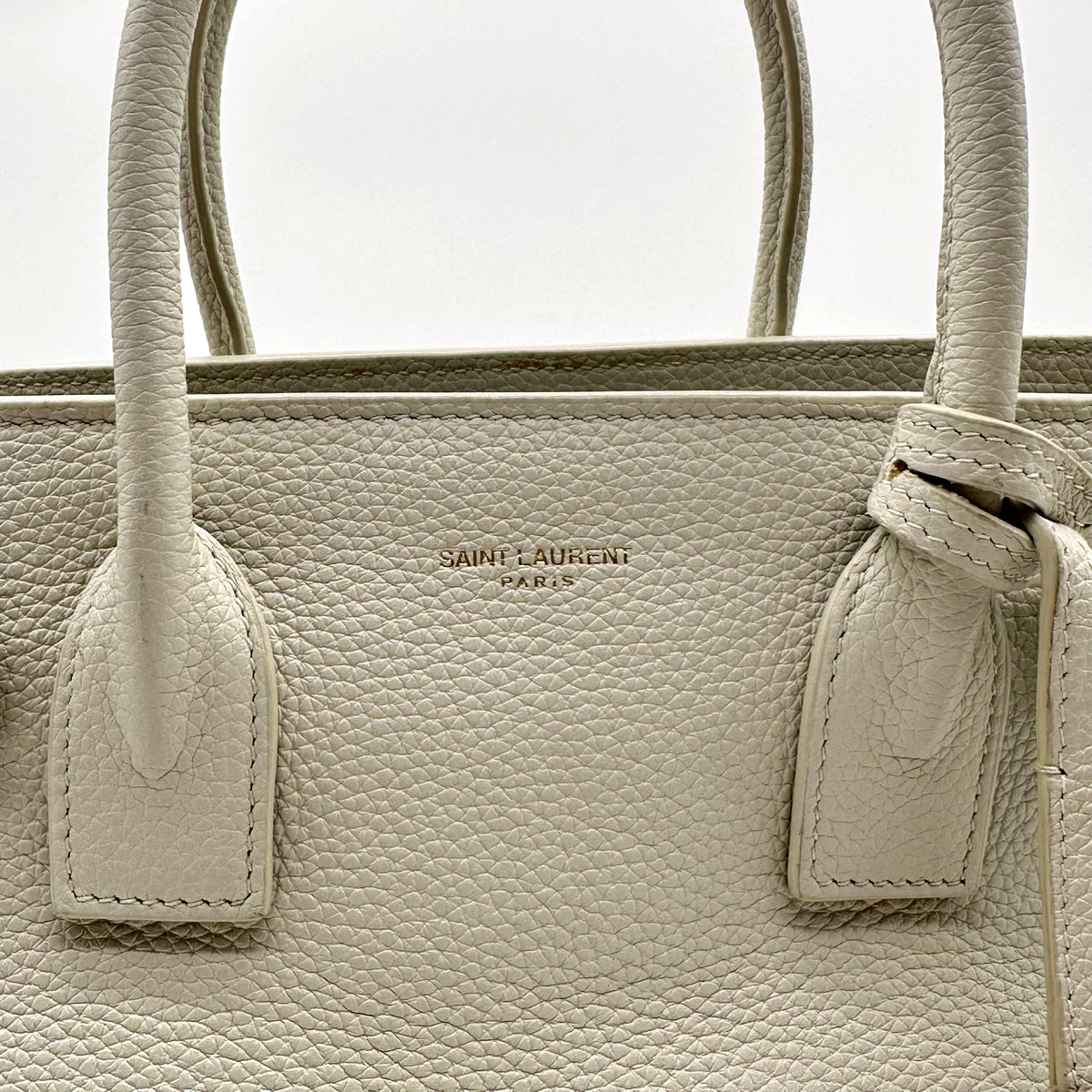 Saint Laurent Sac de Jour Baby Cuir Grainé Blanc Cassé - détail du haut du sac et des attaches d'anses