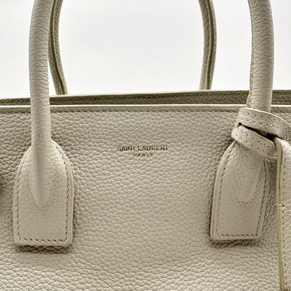 Saint Laurent Sac de Jour Baby Cuir Grainé Blanc Cassé - détail du haut du sac et des attaches d'anses