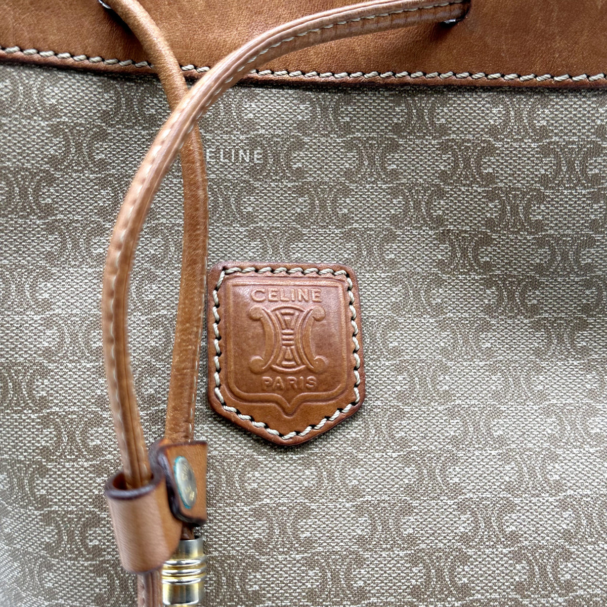 Céline Seau Toile Macadam Beige - détail de l'écusson de cuir et du cordon