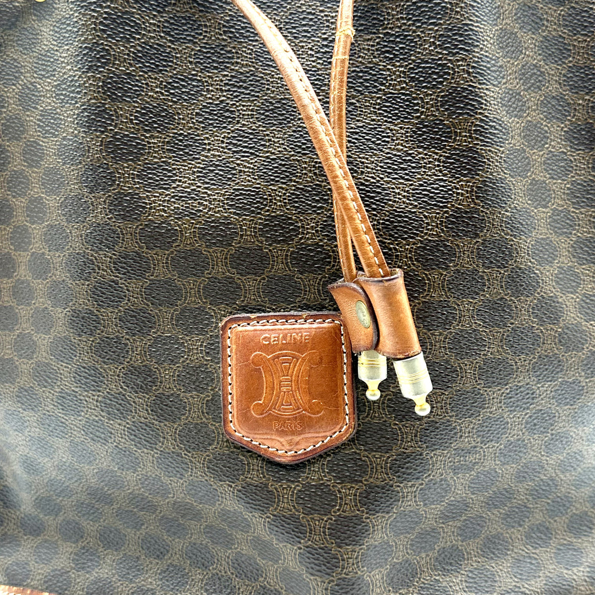 Céline Seau Toile Macadam Brun - détail de l'écusson de cuir et des embouts du cordon