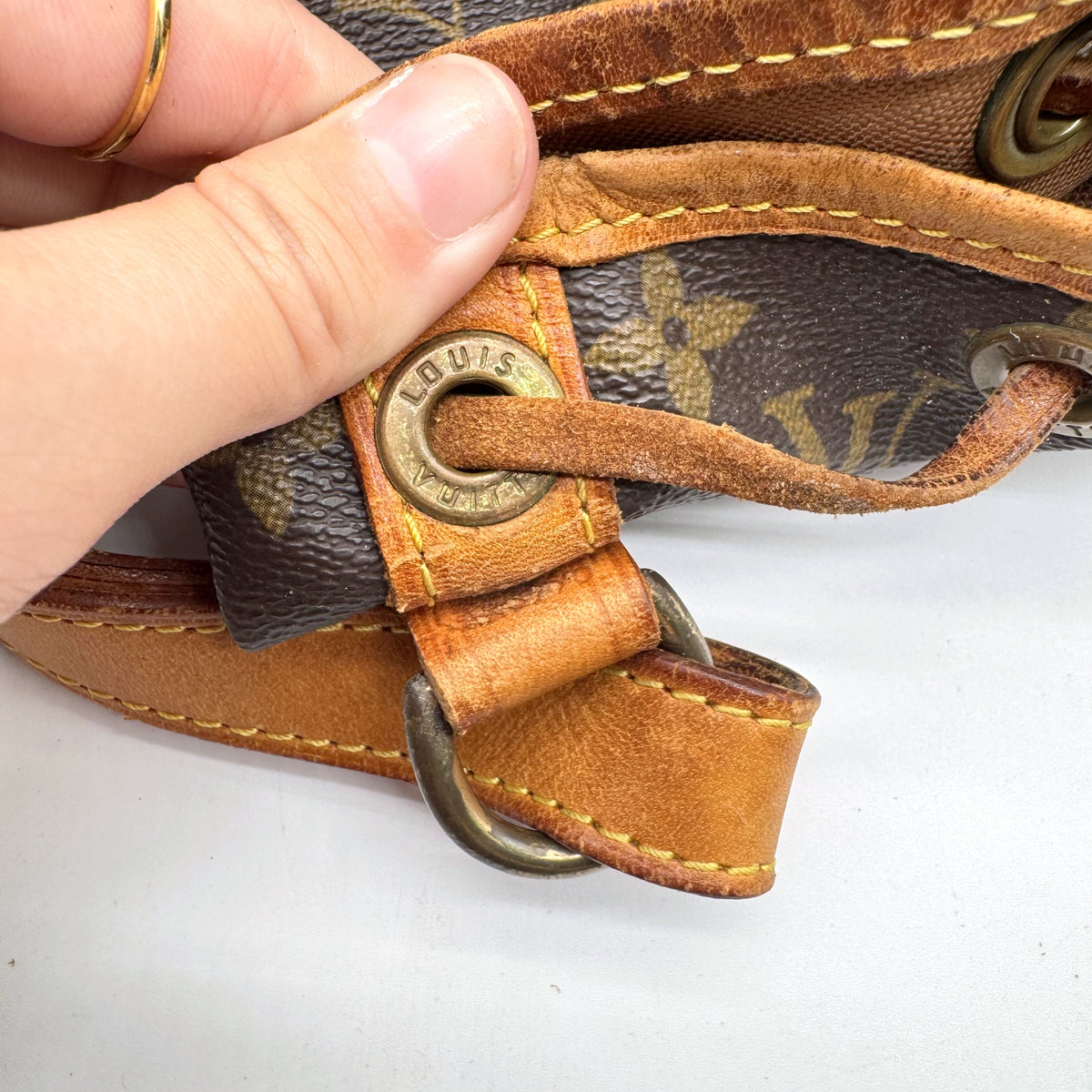 Louis Vuitton Petit Noé Lona Monogram - detalhe do ilhó e da fixação da alça