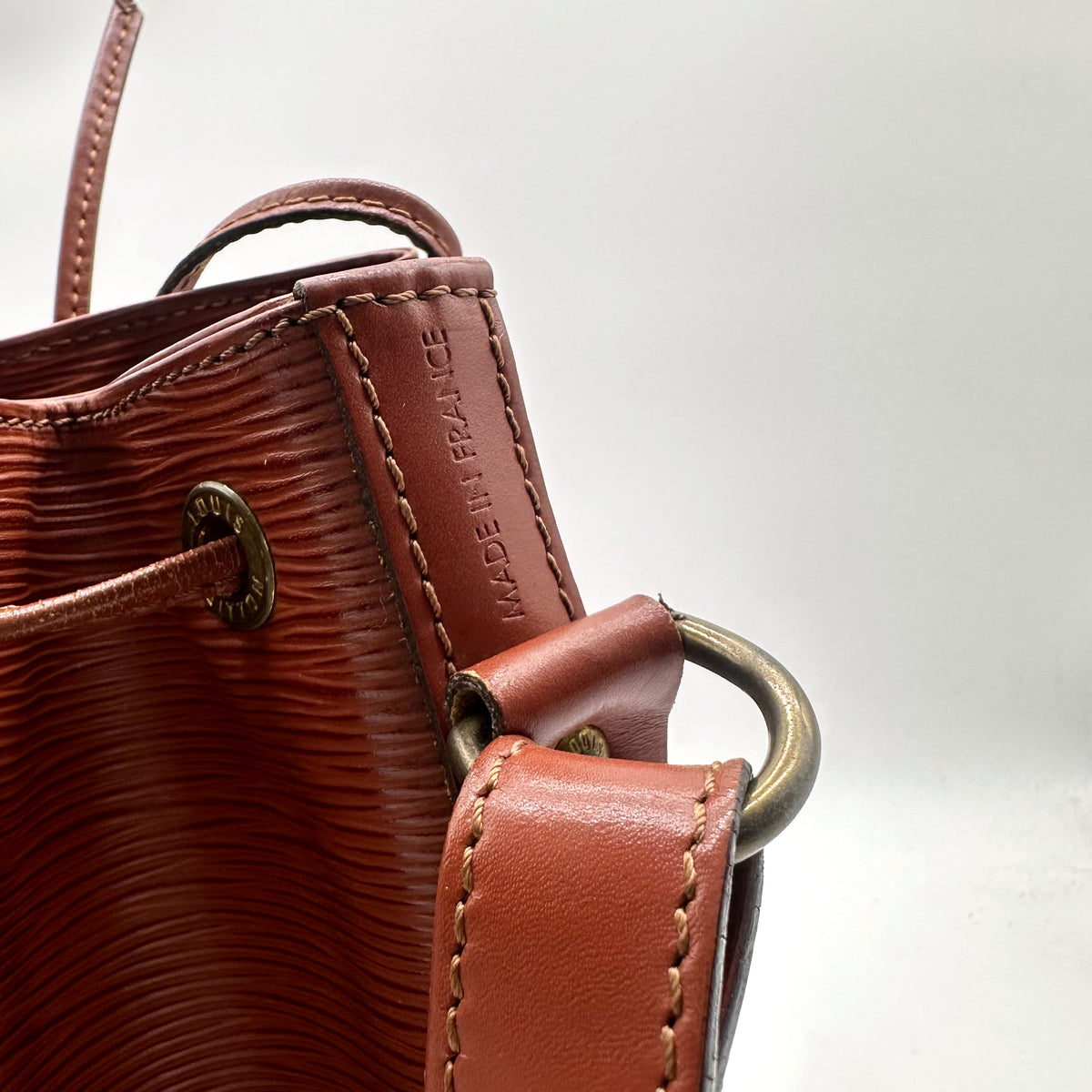 Louis Vuitton Noé Cuir Épi Marron - détail du bord supérieur et des anneaux