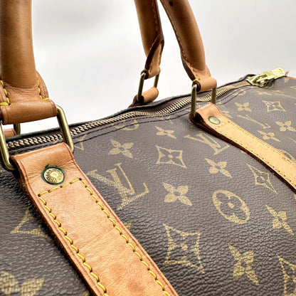 Louis Vuitton Keepall 50 Bandoulière Toile Monogram - détail des attaches d'anses et du cuir naturel