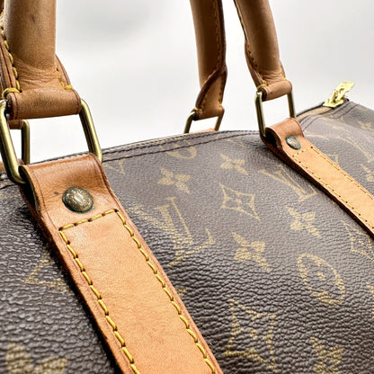 Louis Vuitton Keepall 50 Bandoulière Toile Monogram - détail des attaches d'anses et du cuir naturel
