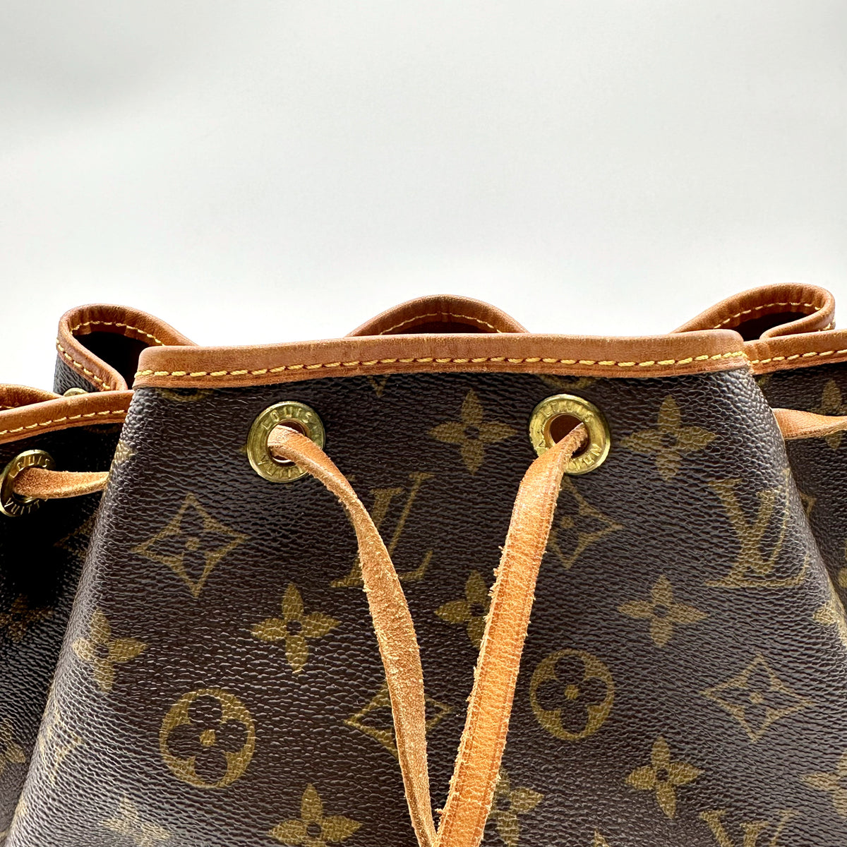 Louis Vuitton Petit Noé Toile Monogram - détail du col, des œillets et du cordon