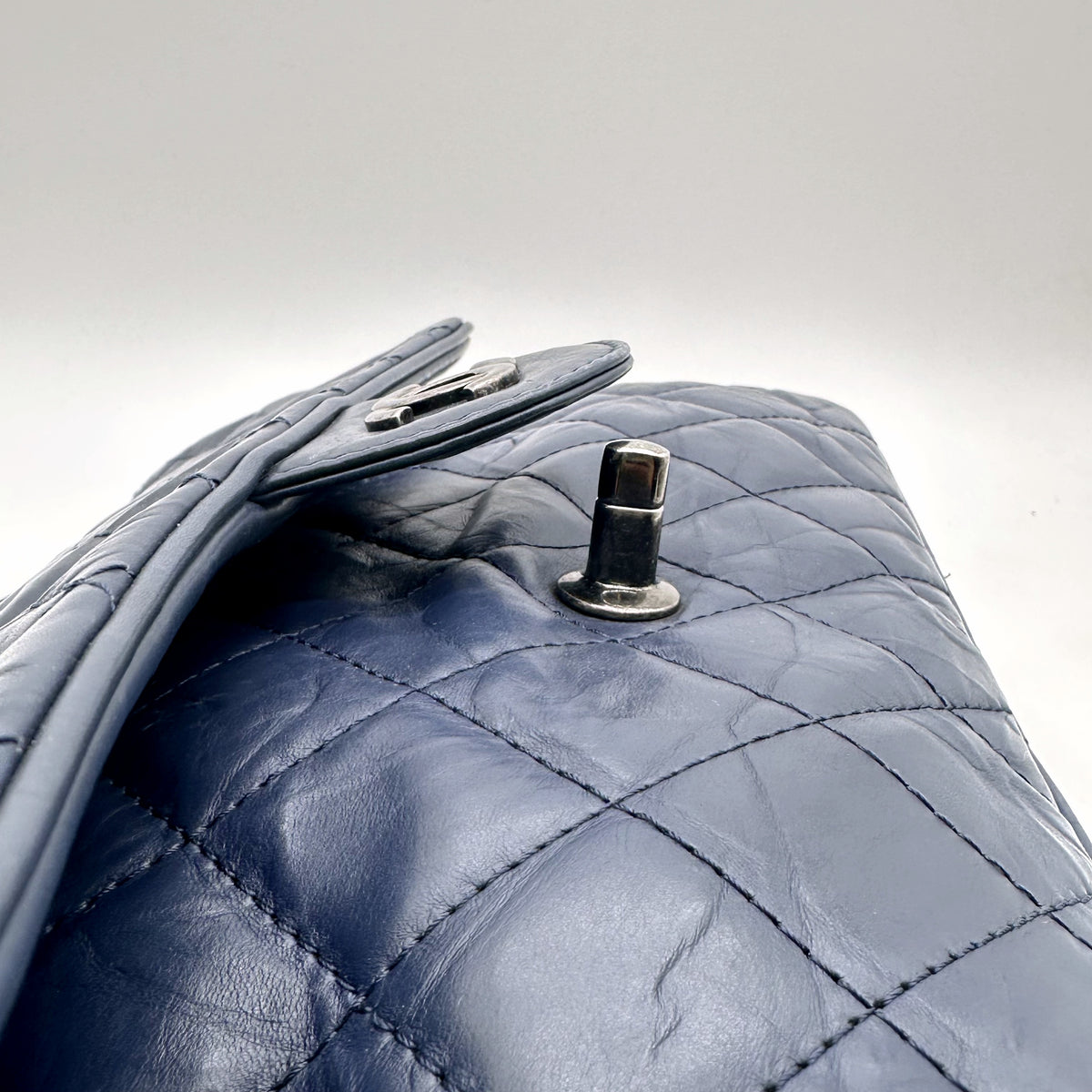 Chanel Matelassé Cuir Bleu Marine - détail du côté et du bouton de fermeture