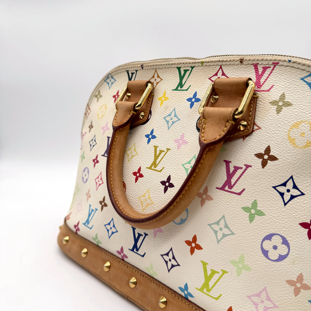 Louis Vuitton Alma Toile Monogram Multicolore Blanc - détail du côté, clous et bordure de cuir