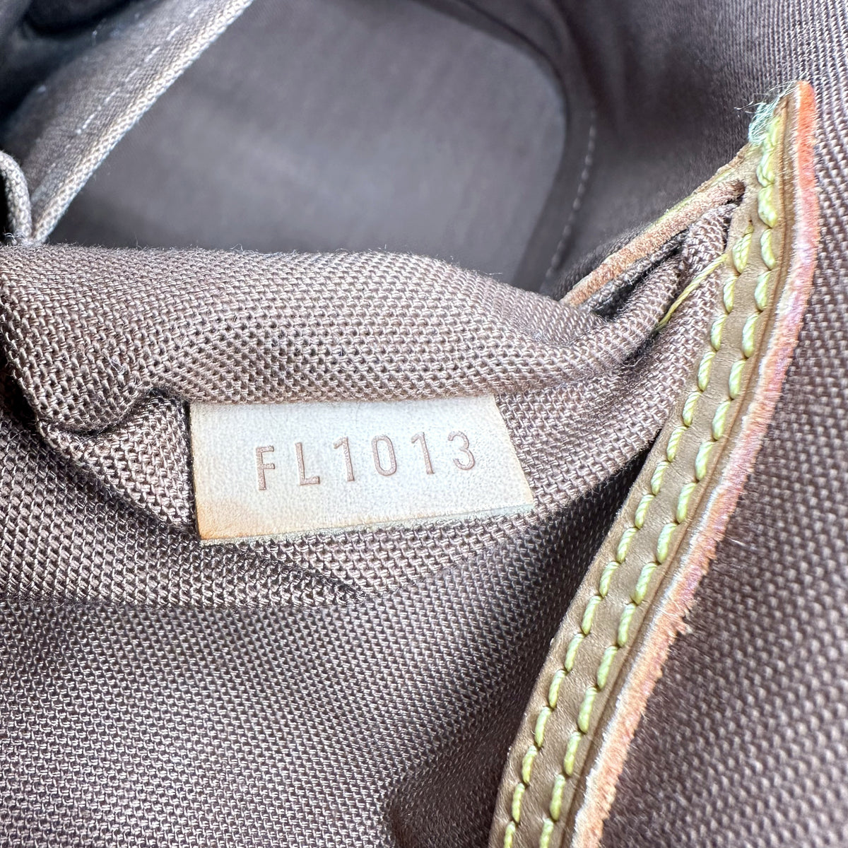 Louis Vuitton Alma Toile Monogram - détail de la doublure intérieure et de sa patte de cuir