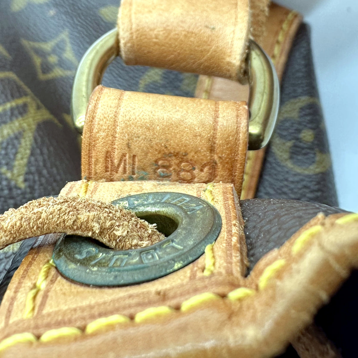 Louis Vuitton Petit Noé Toile Monogram - détail de la patte de cuir et de l'œillet