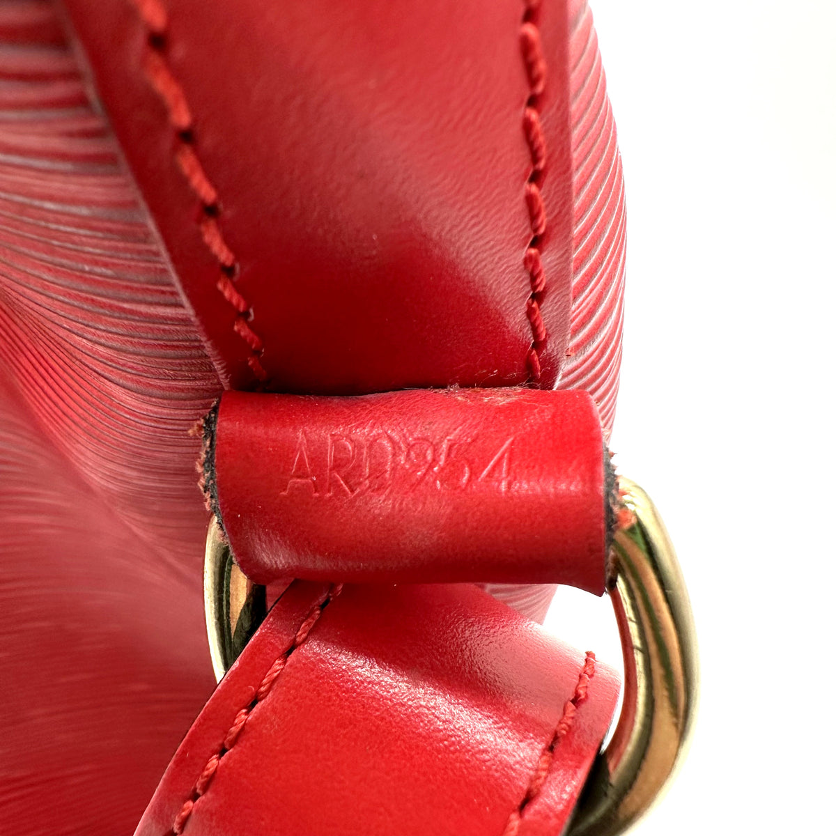 Louis Vuitton Noé Cuir Épi Rouge - détail de la patte de cuir portant le code