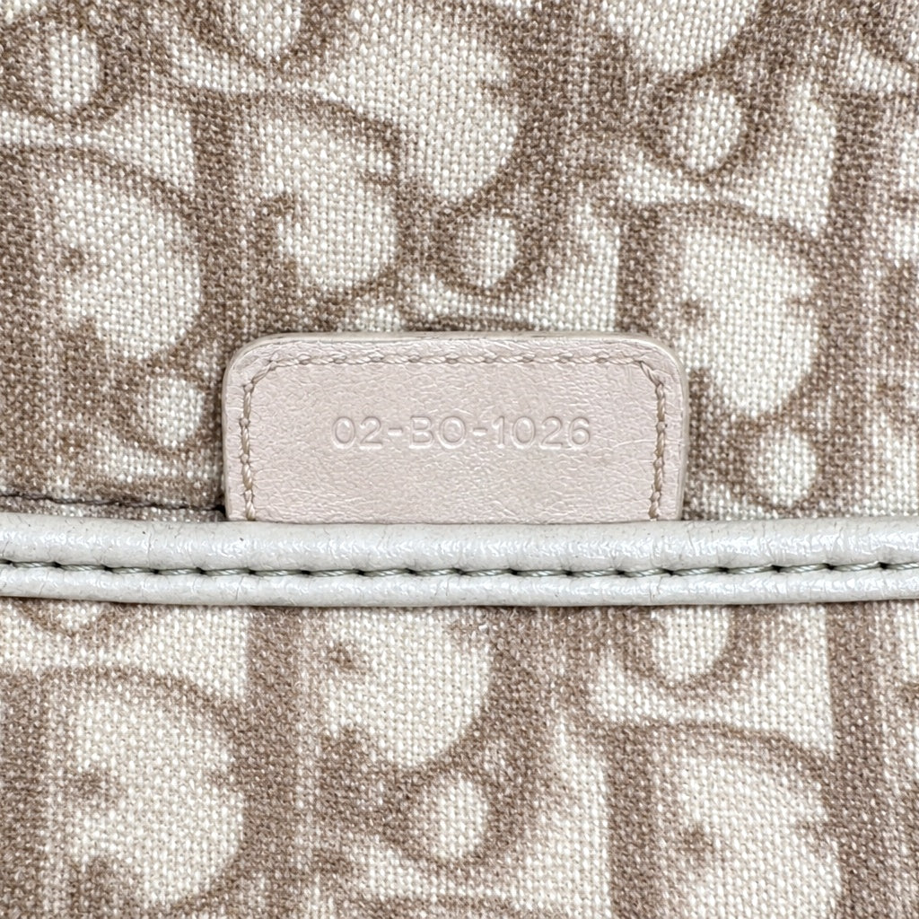 Dior Cabas Toile Trotter Beige - détail de la patte de cuir portant le code
