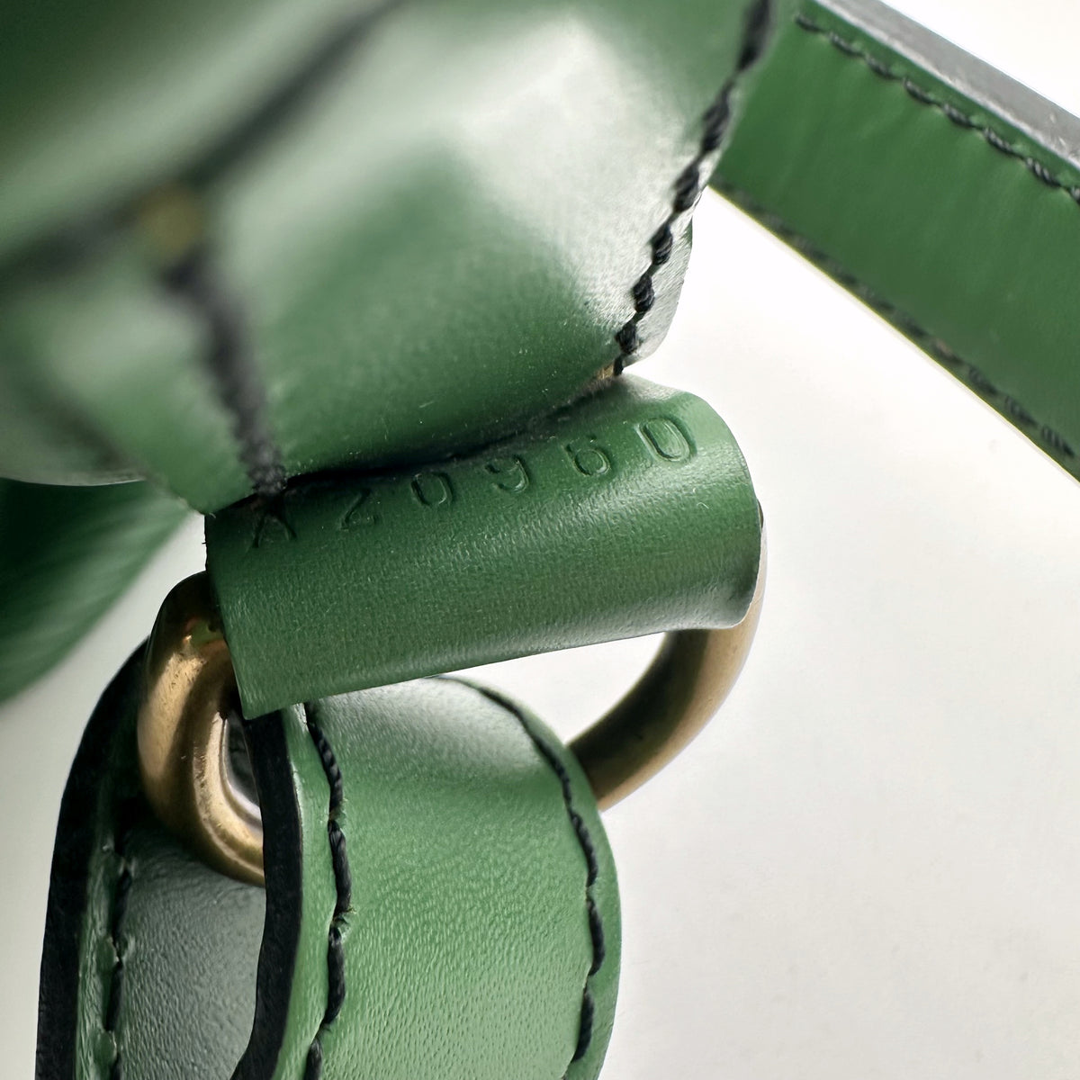 Louis Vuitton Petit Noé Cuir Épi Vert - détail de la patte de cuir et de l'anneau