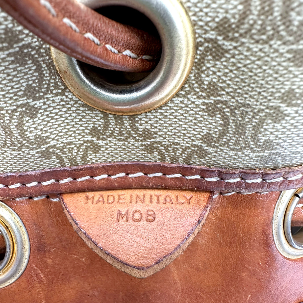 Céline Seau Toile Macadam Beige - détail d'un œillet et de la patte de cuir intérieure