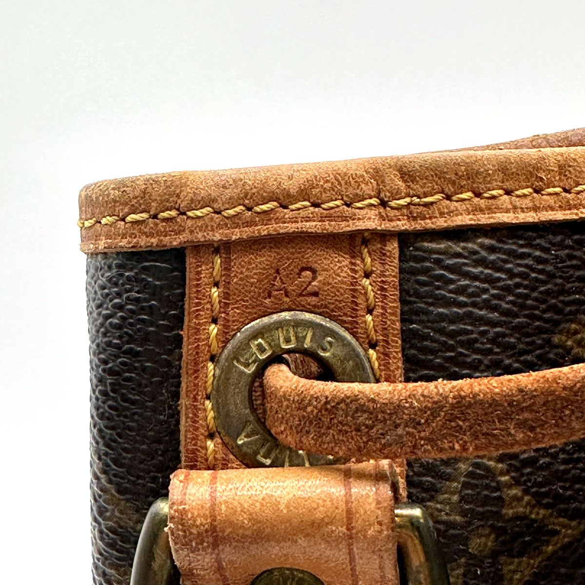 Louis Vuitton Noé Toile Monogram - détail d'un œillet et de la patte de cuir