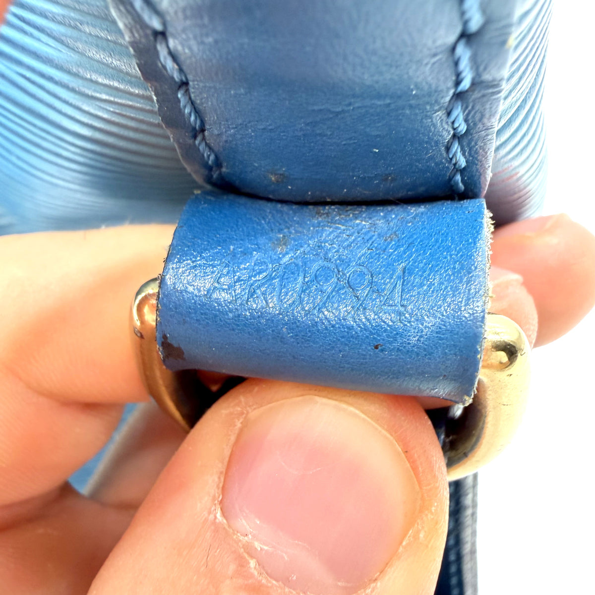 Louis Vuitton Petit Noé cuir Épi bleu - gros plan de la patte de cuir craquelée à l'attache