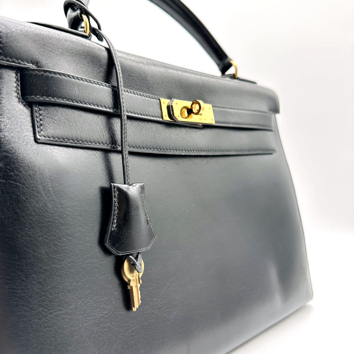 Hermès Kelly 32 Cuir Box Calf Noir - vue rapprochée de face, sangles et clochette