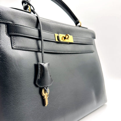 Hermès Kelly 32 Cuir Box Calf Noir - vue rapprochée de face, sangles et clochette