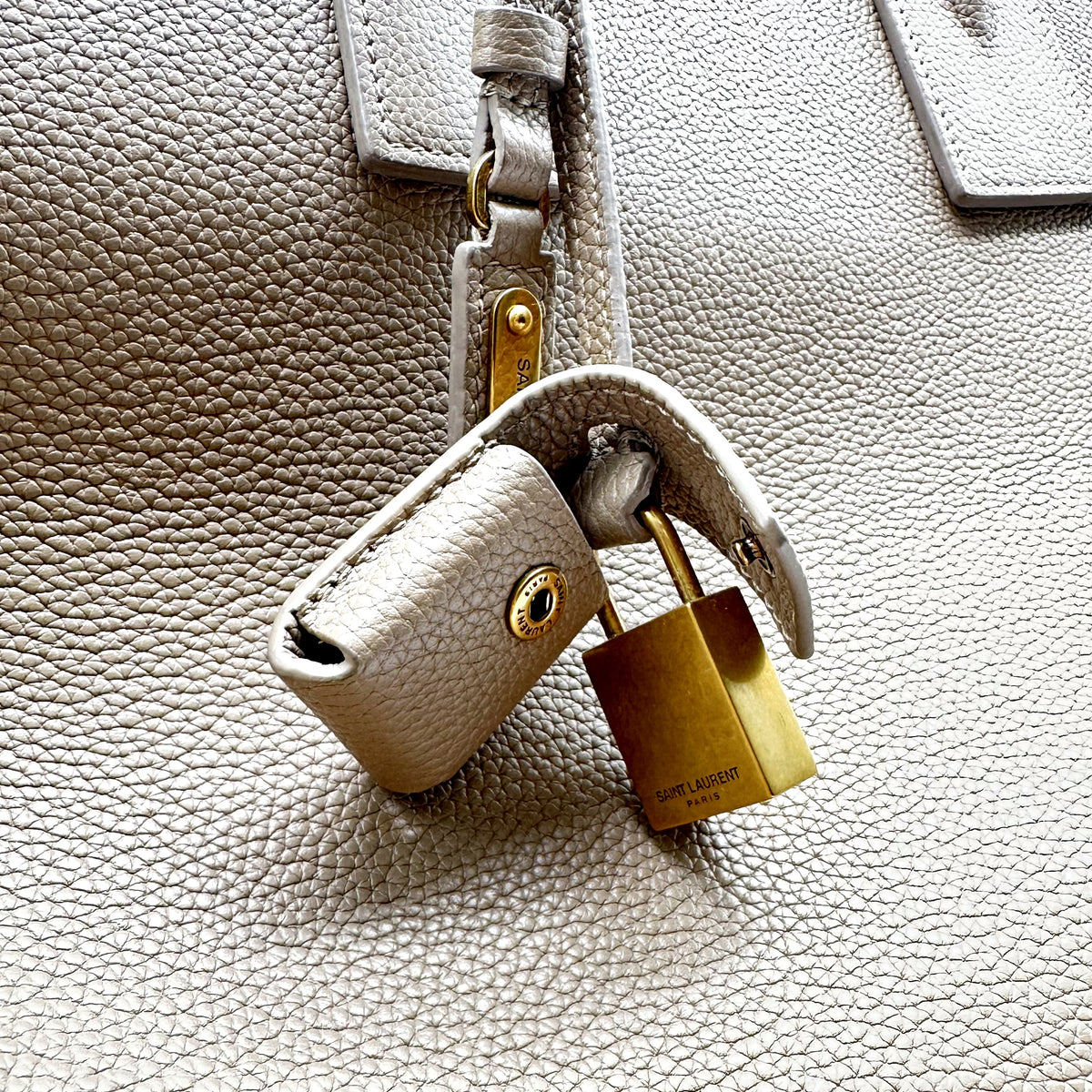 Saint Laurent Bandoulière Cuir Grainé Taupe - détail du cadenas doré et de sa clochette