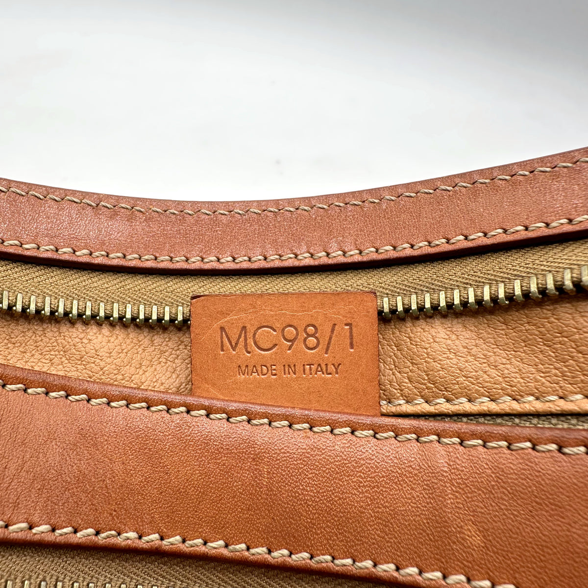 Céline Pochette Toile Macadam - détail de la patte de cuir portant le code