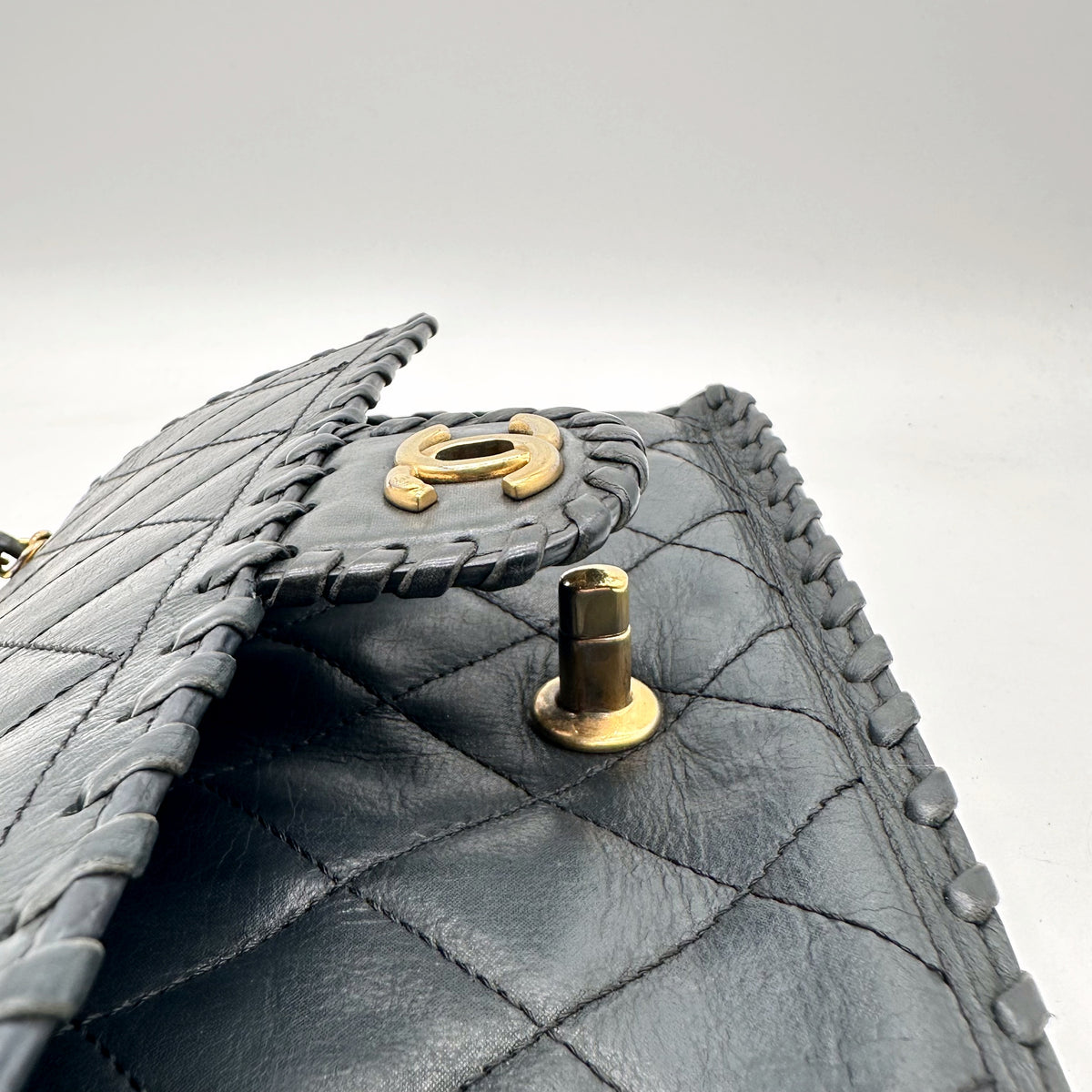 Chanel Matelassé Cuir Gris Anthracite - détail du plot de fermoir et du rabat relevé