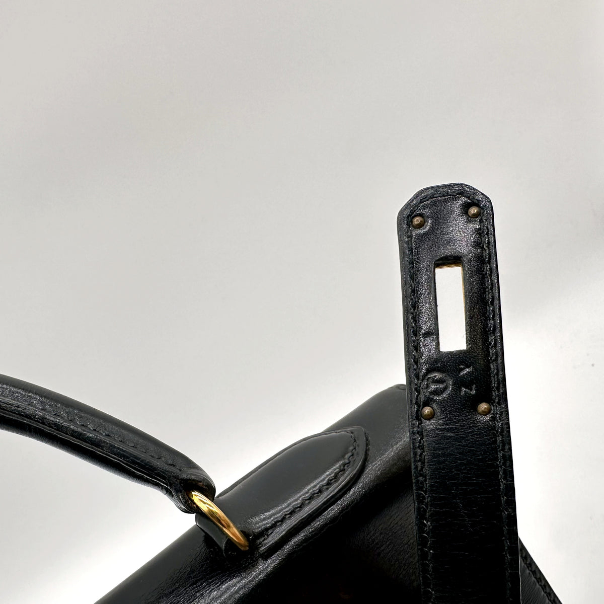 Hermès Kelly 32 Cuir Box Calf Noir - détail du haut du sac et de l'attache d'anse