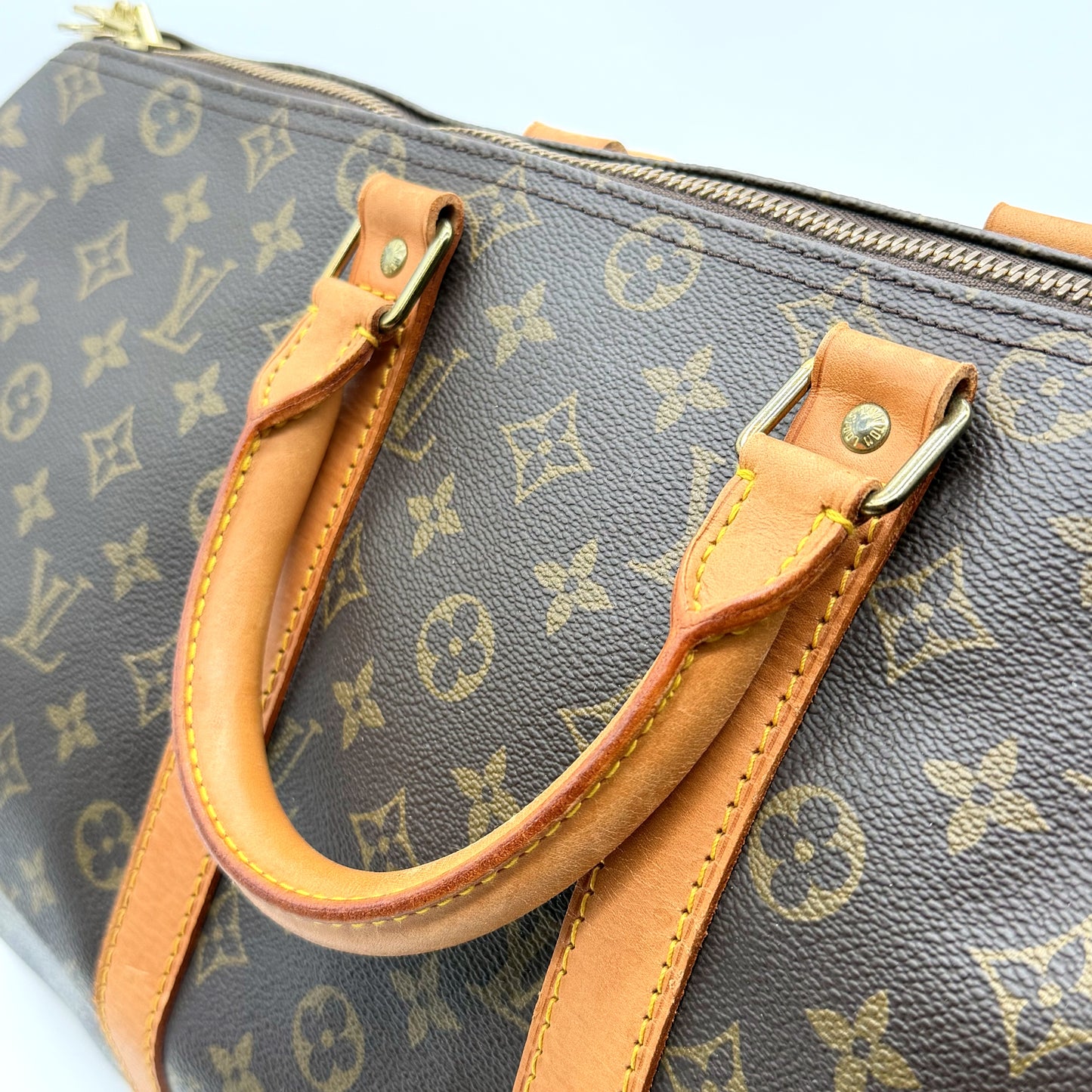 Louis Vuitton Keepall 45 Toile Monogram - détail attaches laiton doré et anses